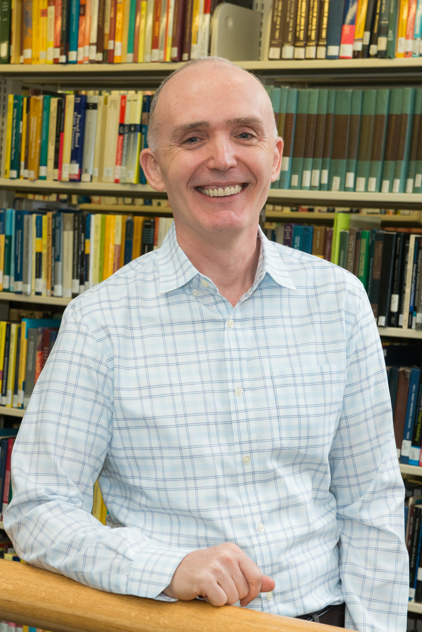 A man standing in front of book shelves